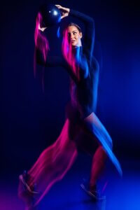 OHM Fitness female athlete with colorful motion light streaks in Phoenix commercial photography